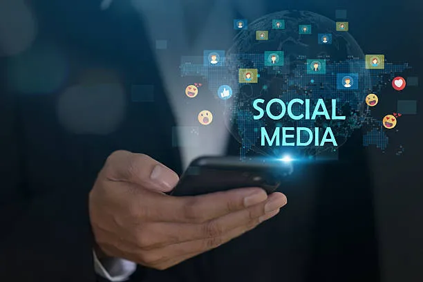 Ilustración de equipo de trabajo colaborando en oficina con emojis de redes sociales representando la mejor red social para negocio en entornos digitales.